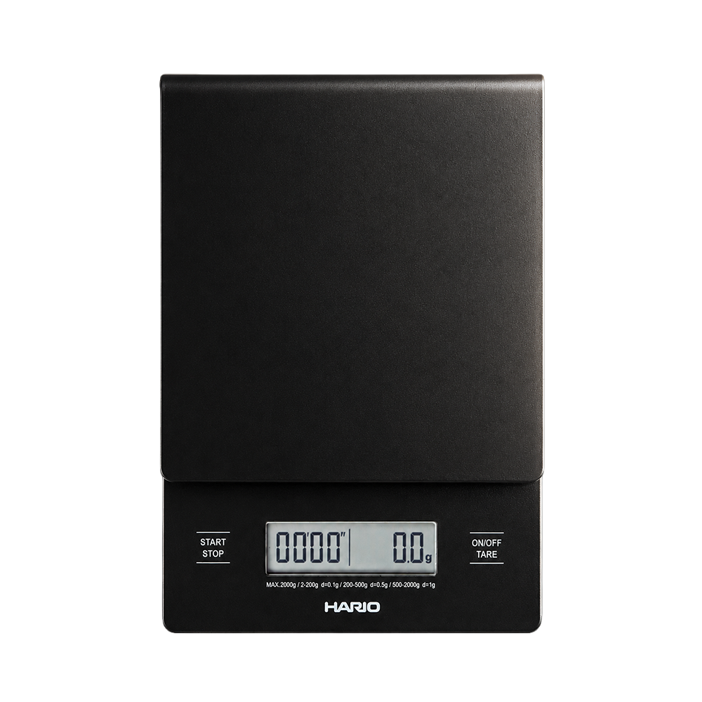 A HARIO digital scale in matte black, featuring a large flat weighing platform and an integrated LCD display showing weight measurements, set against a plain white background.