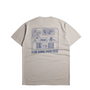 A light beige crewneck t-shirt shown from the back, featuring a blue line art graphic of a table with a plant and the text 'SLOW DOWN, POUR OVER'.